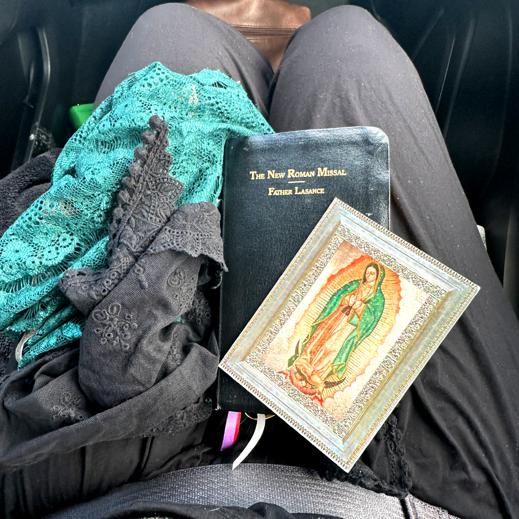 Missal and chapel veils on woman's lap taking kids to mass alone