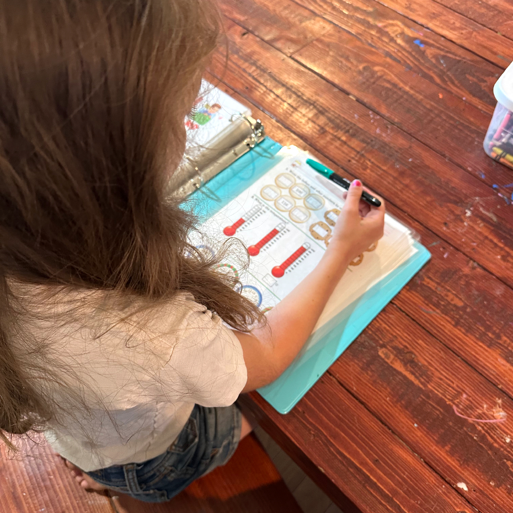 girl with math book at table, homeschooling 4 kids, large family